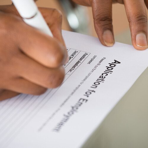 Person filling out job application.