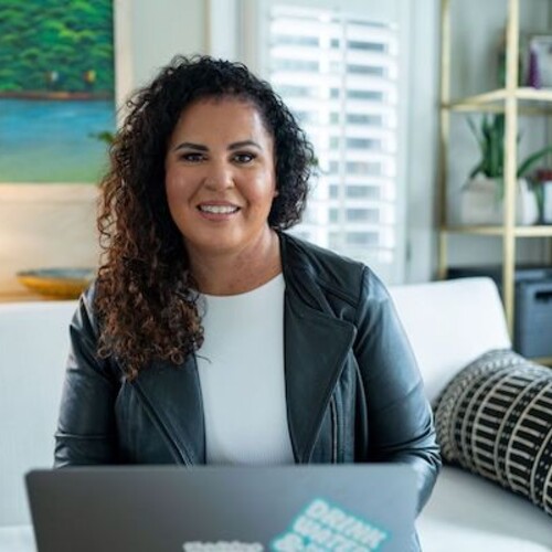 Safiya Noble sitting behind a laptop.