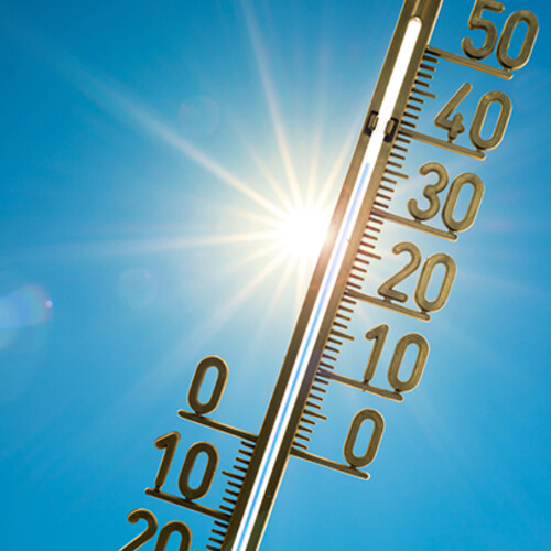 An image of thermometer with blazing sun in the background. 