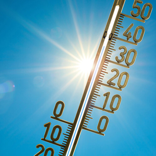 An image of thermometer with blazing sun in the background.