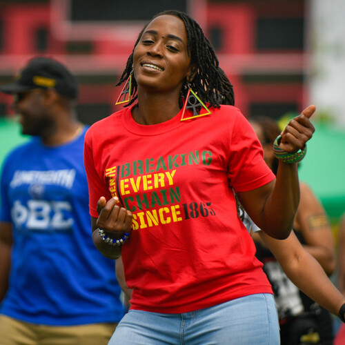 Person dancing at a Juneteenth celebration wearing a t-shirt that reads BREAKING EVERY CHAIN SINCE 1865.