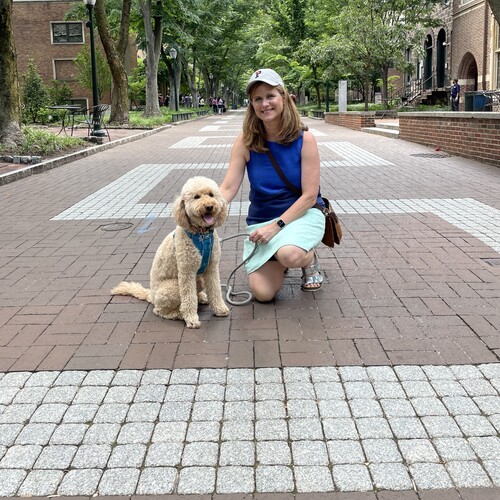 Liz Magill with goldendoodle dog on Locust Walk