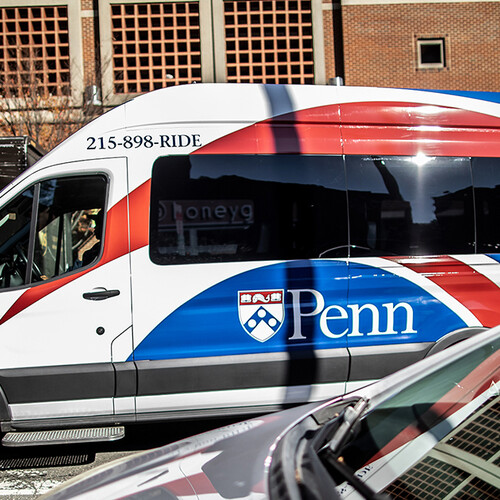 A passenger van driving between two cars