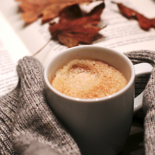 Coffee mug full of drinks and books.