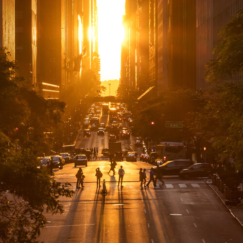 A low sun shines on a city street 