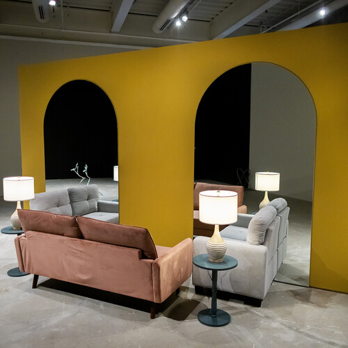 Love seats and side tables placed in front of arched mirrors.