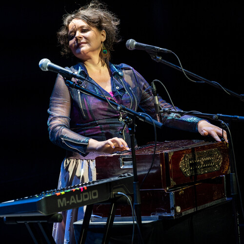 Mariana plays an instrument on stage.