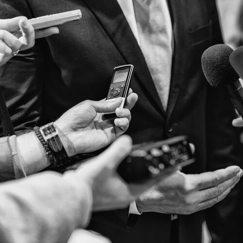 Cropped Hands Of Journalists Interviewing a politician.