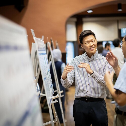 A student talks with an attendee about their poster during Penn’s CURF Poster Expo in Houston Hall.