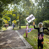 Scarecrow decorated in an American flag and grey wig, with a vote sign and more scarecrows in the background