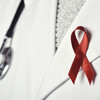 A red ribbon and stethoscope atop a doctor's coat