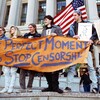 Group of protesters on steps with sign that reads The Perfect Moment to Stop Censorship
