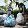 Two masked people tie up bags of trash collected from Penn's campus