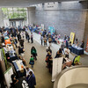 People walking around a lobby where various tables are set up.