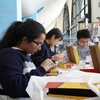 Three students working on a DIY robotics kit at the Education Commons.
