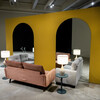Love seats and side tables placed in front of arched mirrors. 
