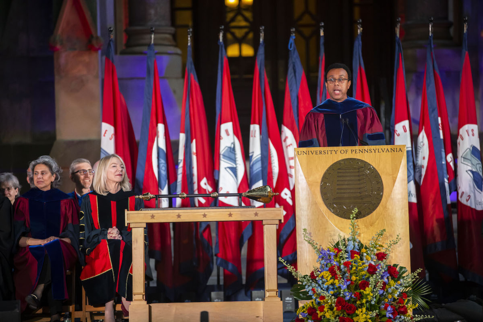 Penn Provost Wendell Pritchett speaks at the podium during convocation with Amy Gutmann and others seated to his right
