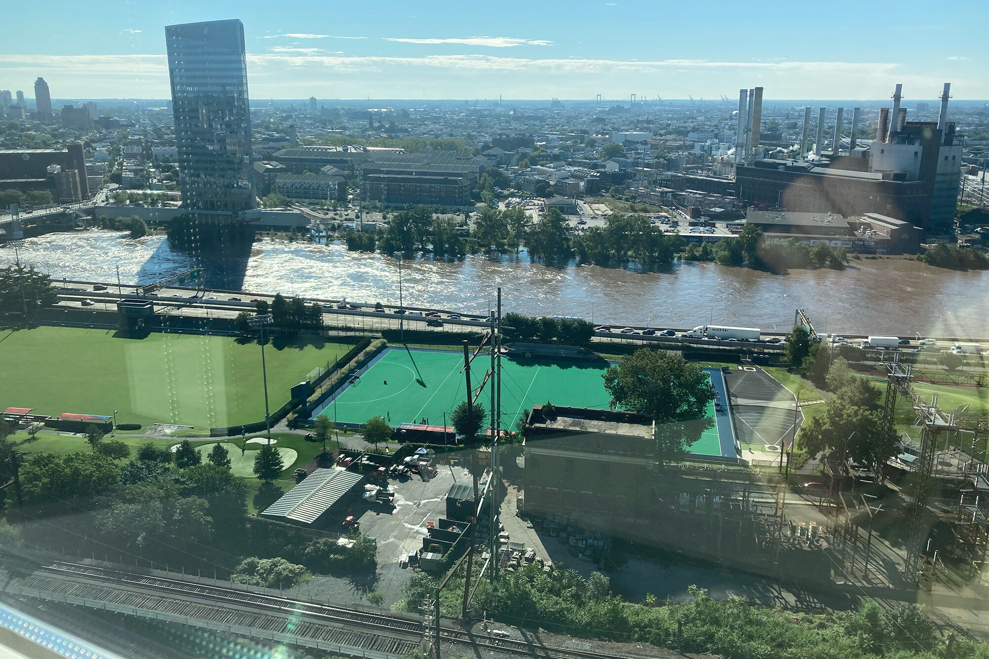 View  from a high window of Schuykill River flooded, with sporting fields and city of Philadelphia. 