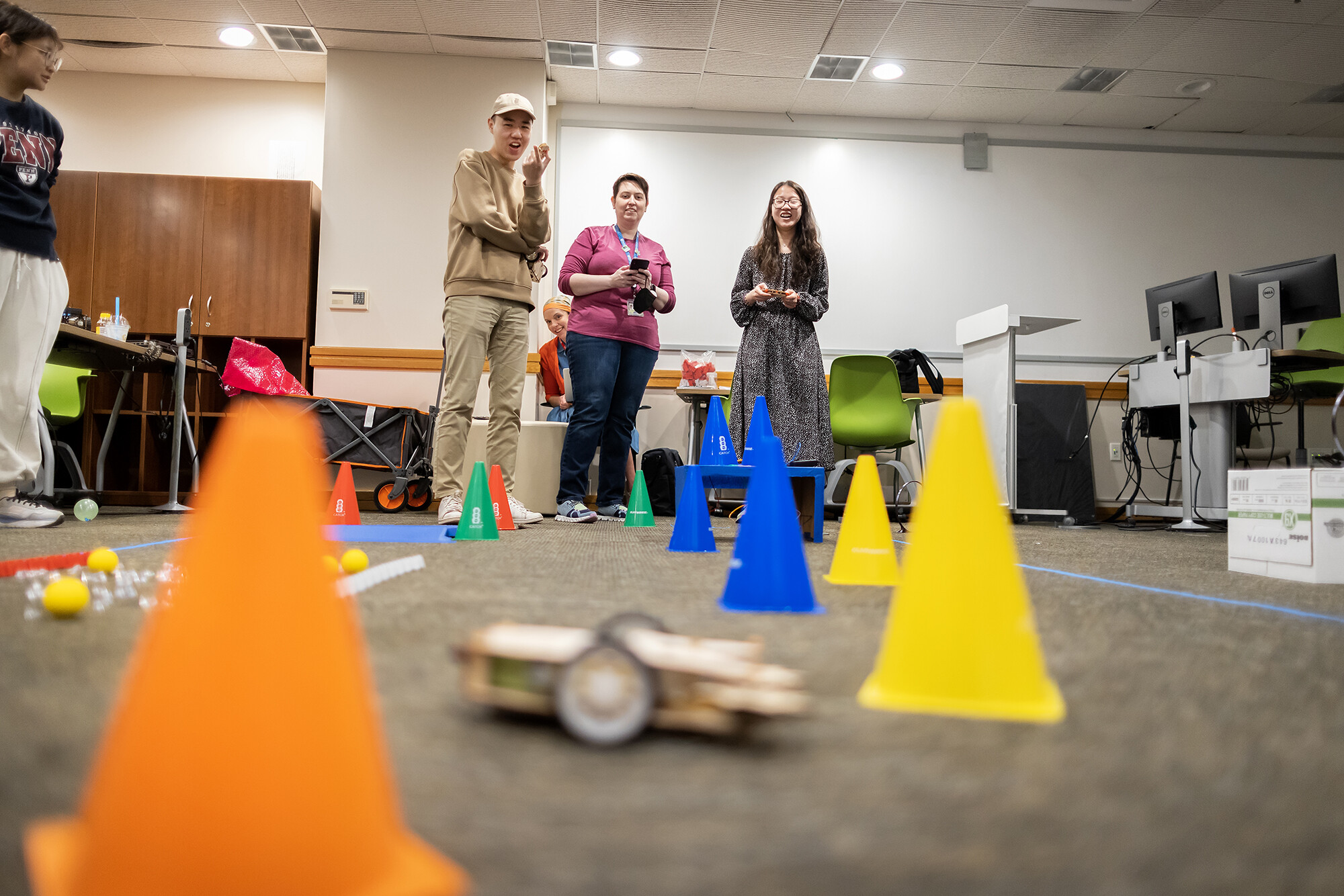 students watch maker space bots compete in cones