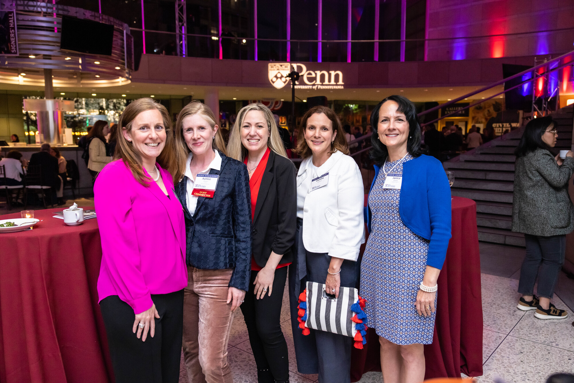 5 people smile for a photo at event with Penn branding in background