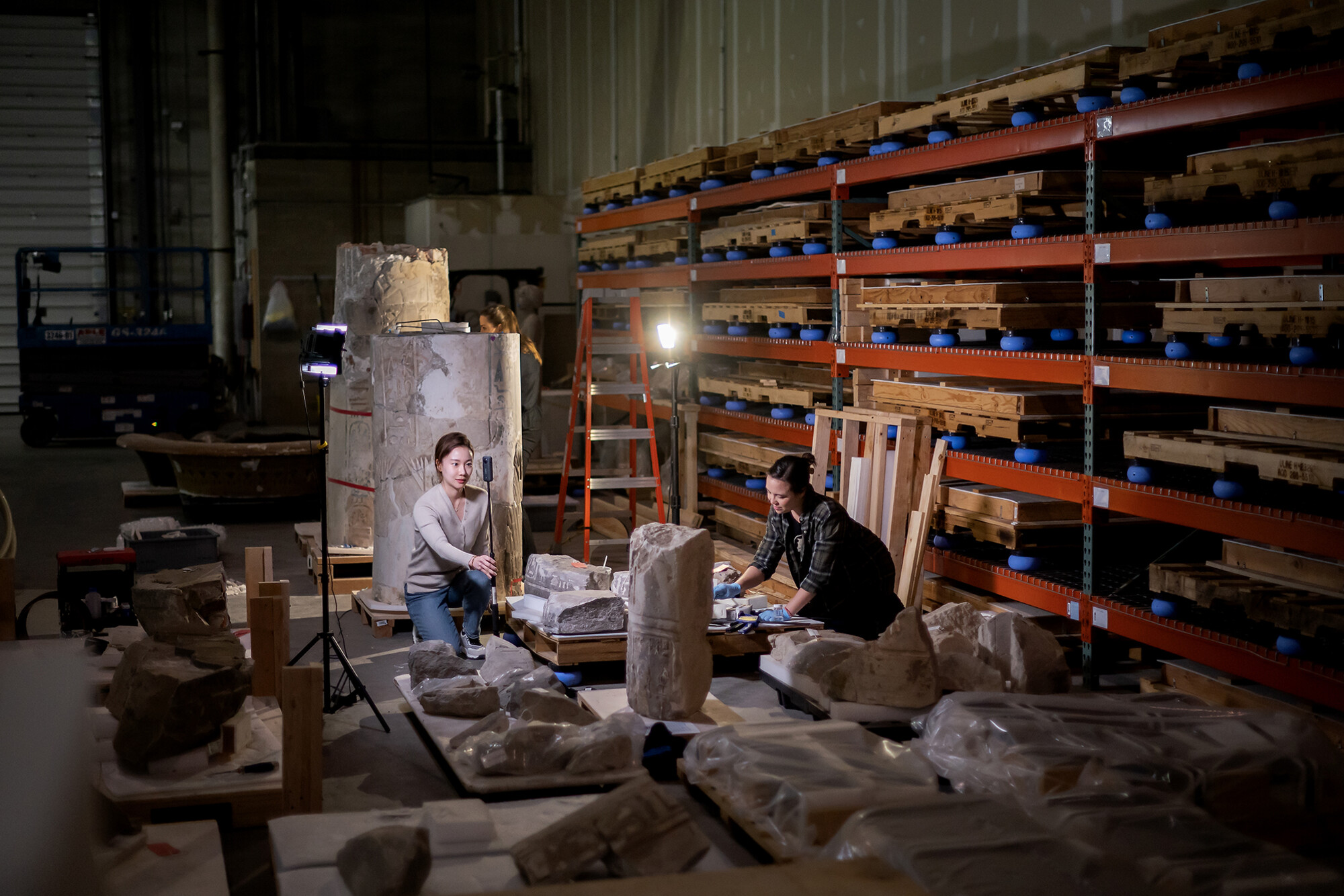 Two students in the warehouse of the Penn Museum testing recording equipment.