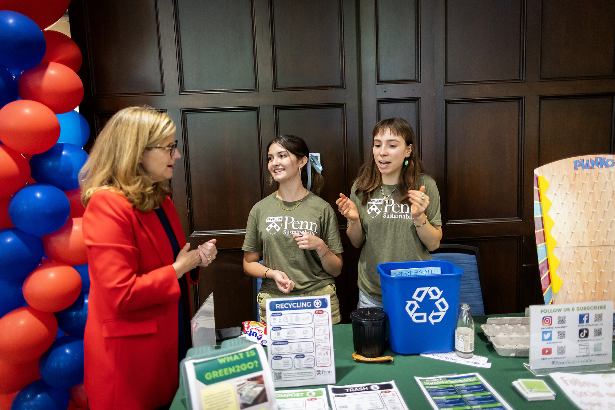 Penn President Liz Magill and two students at table at the Penn NSO resource fair.