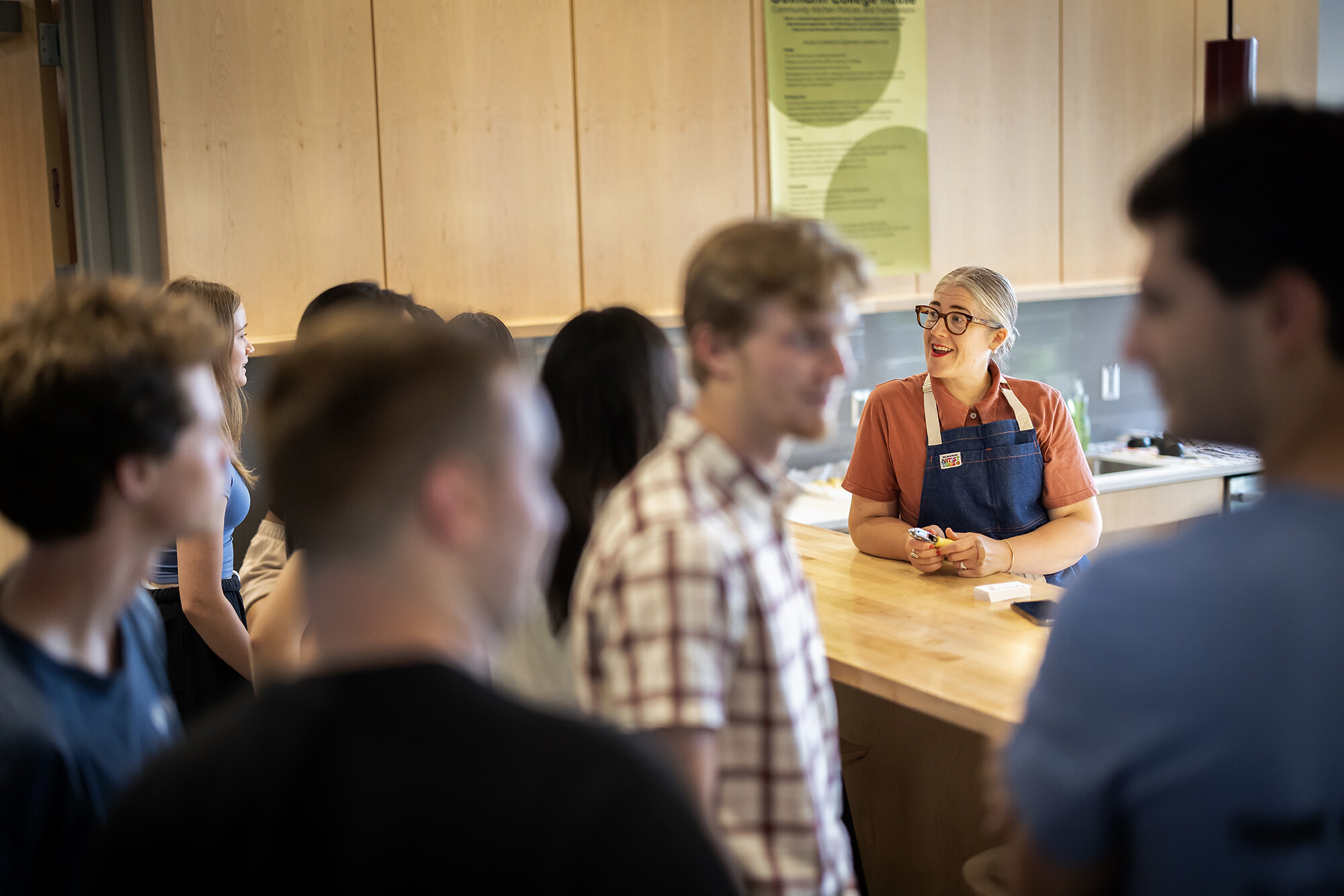 kathryn greets new students in the gutmann college house kitchen