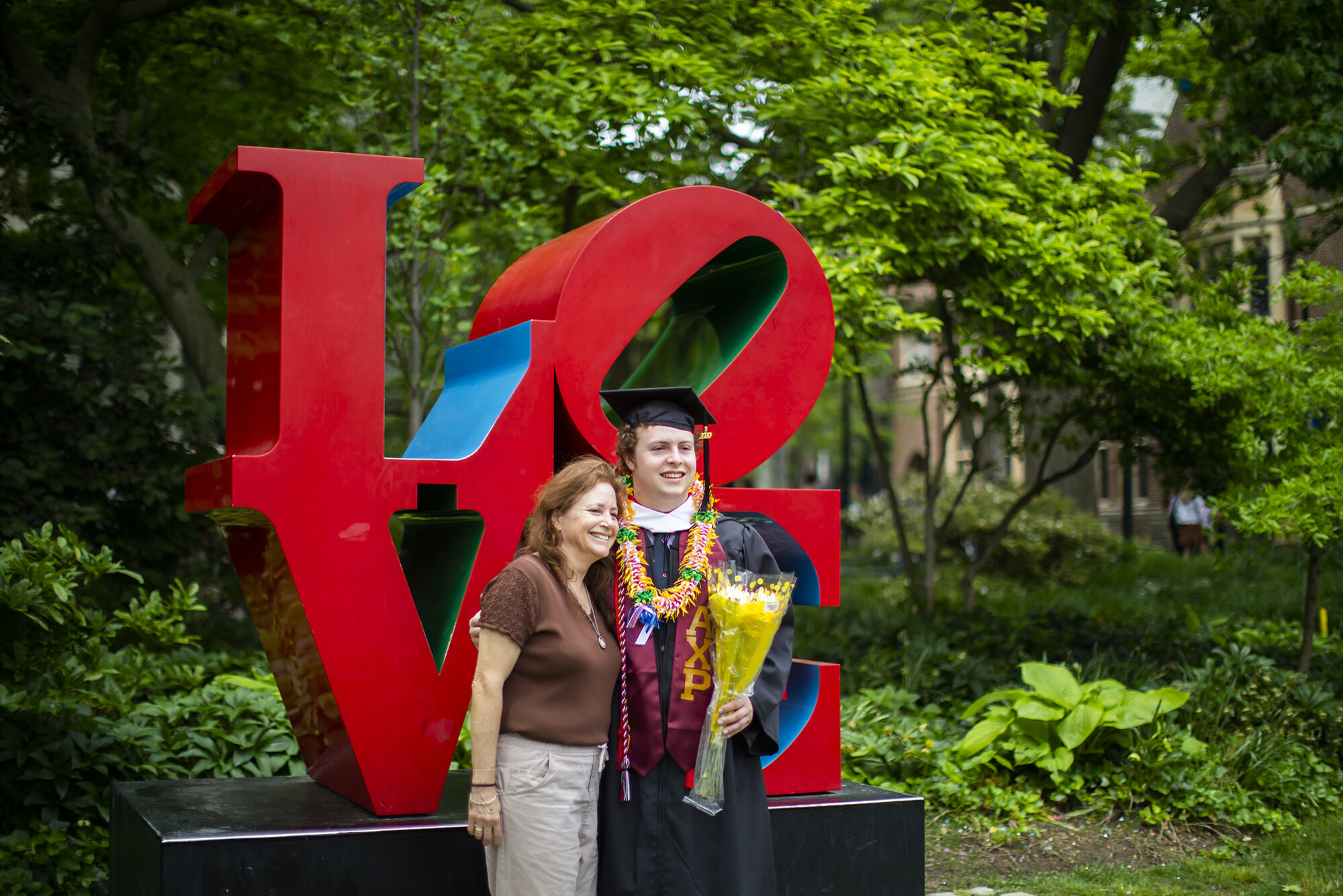 A family in front of Robert Indiana’s LOVE statue on Penn’s Commencement day.