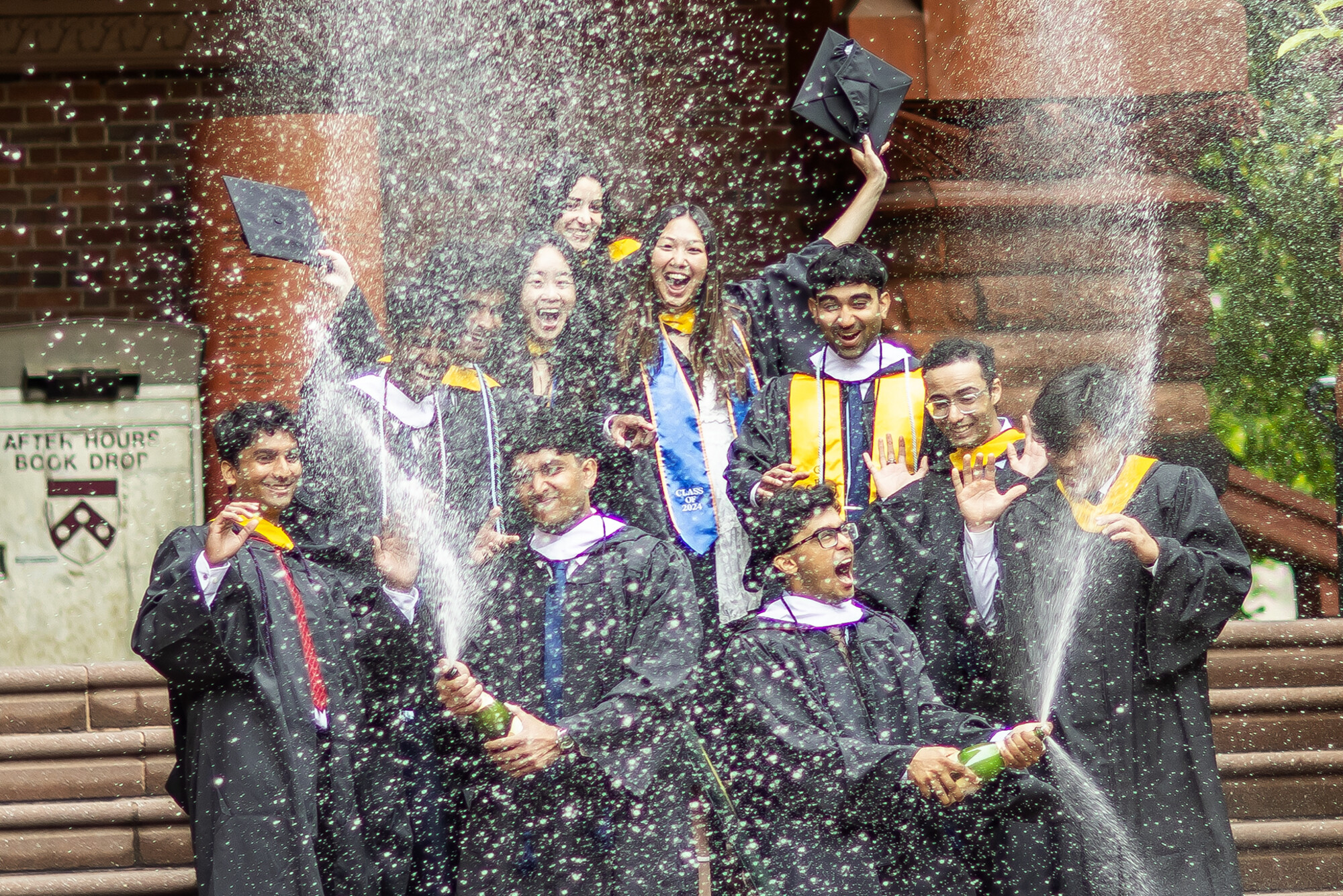 student celebrate with champagne during commencement
