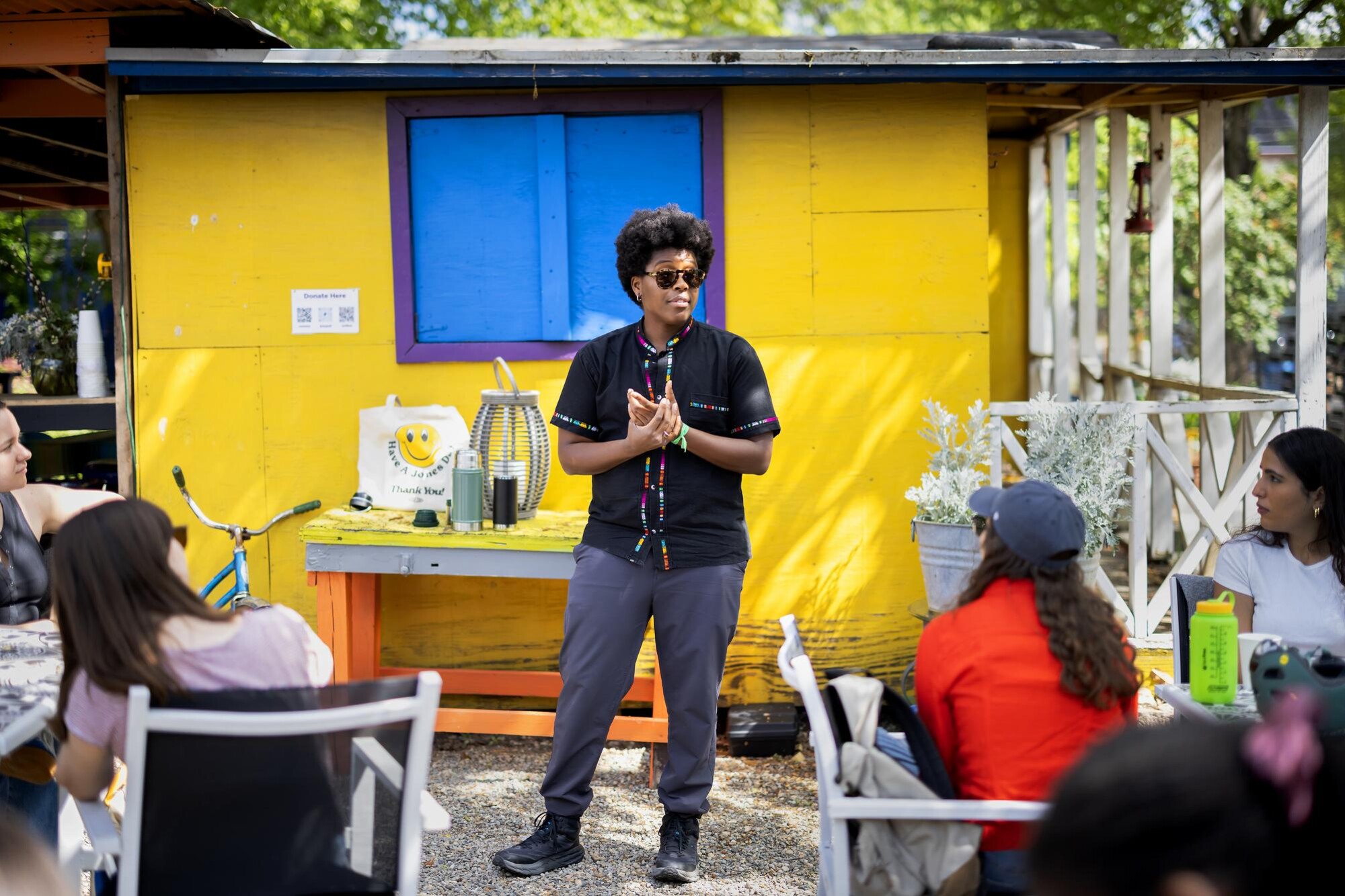 A person lectures Penn students at an outdoor farm.