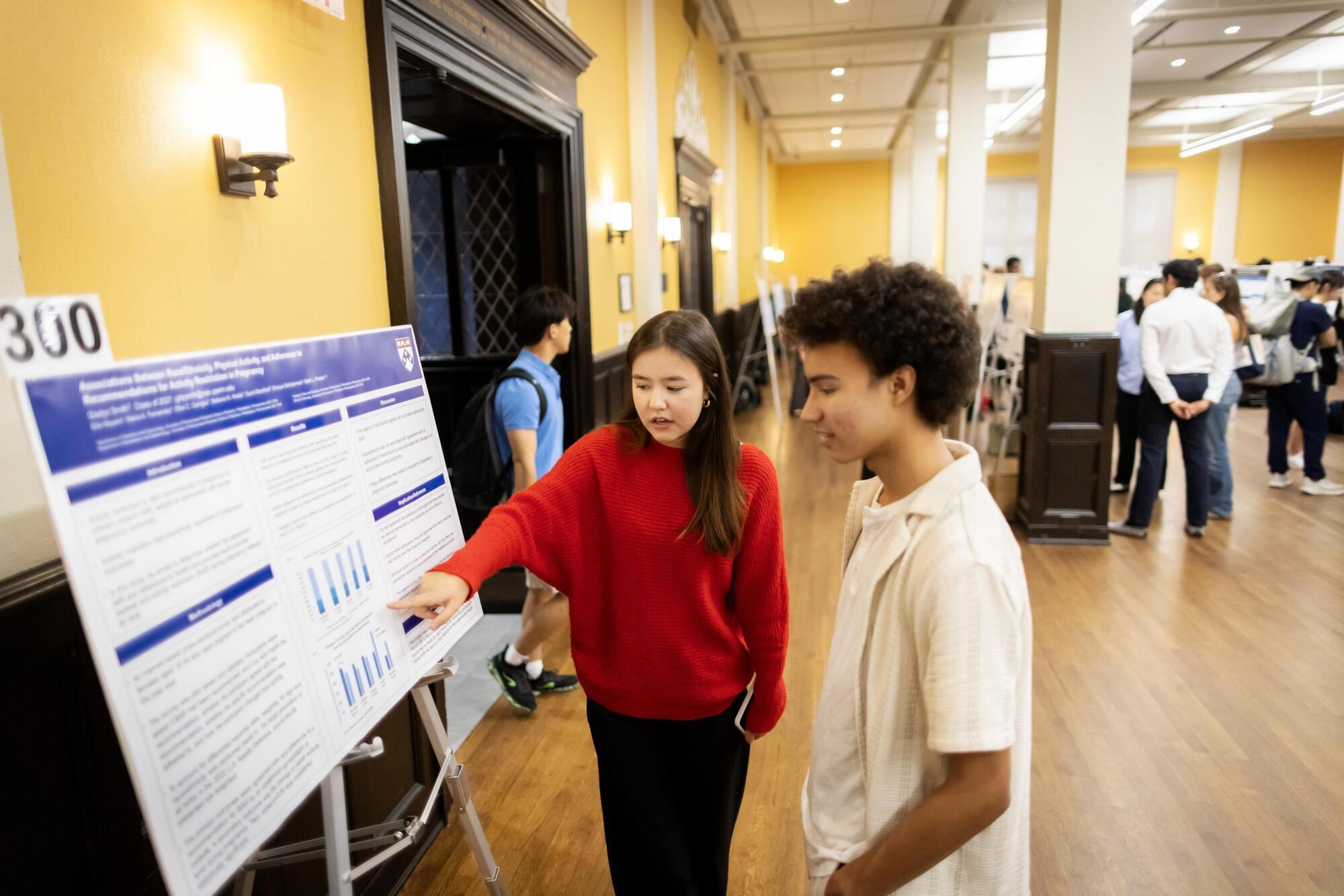 Gladys Smith talks with another student at the CURF Poster Expo in Penn’s Houston Hall.