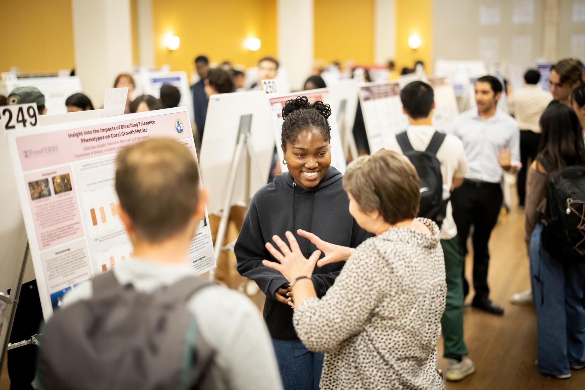 A student talks with an attendee about their poster during Penn’s CURF Poster Expo in Houston Hall.