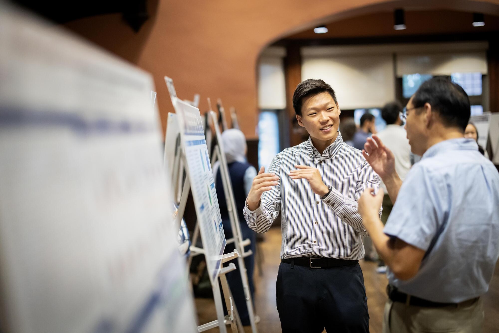 A student talks with an attendee about their poster during Penn’s CURF Poster Expo in Houston Hall.