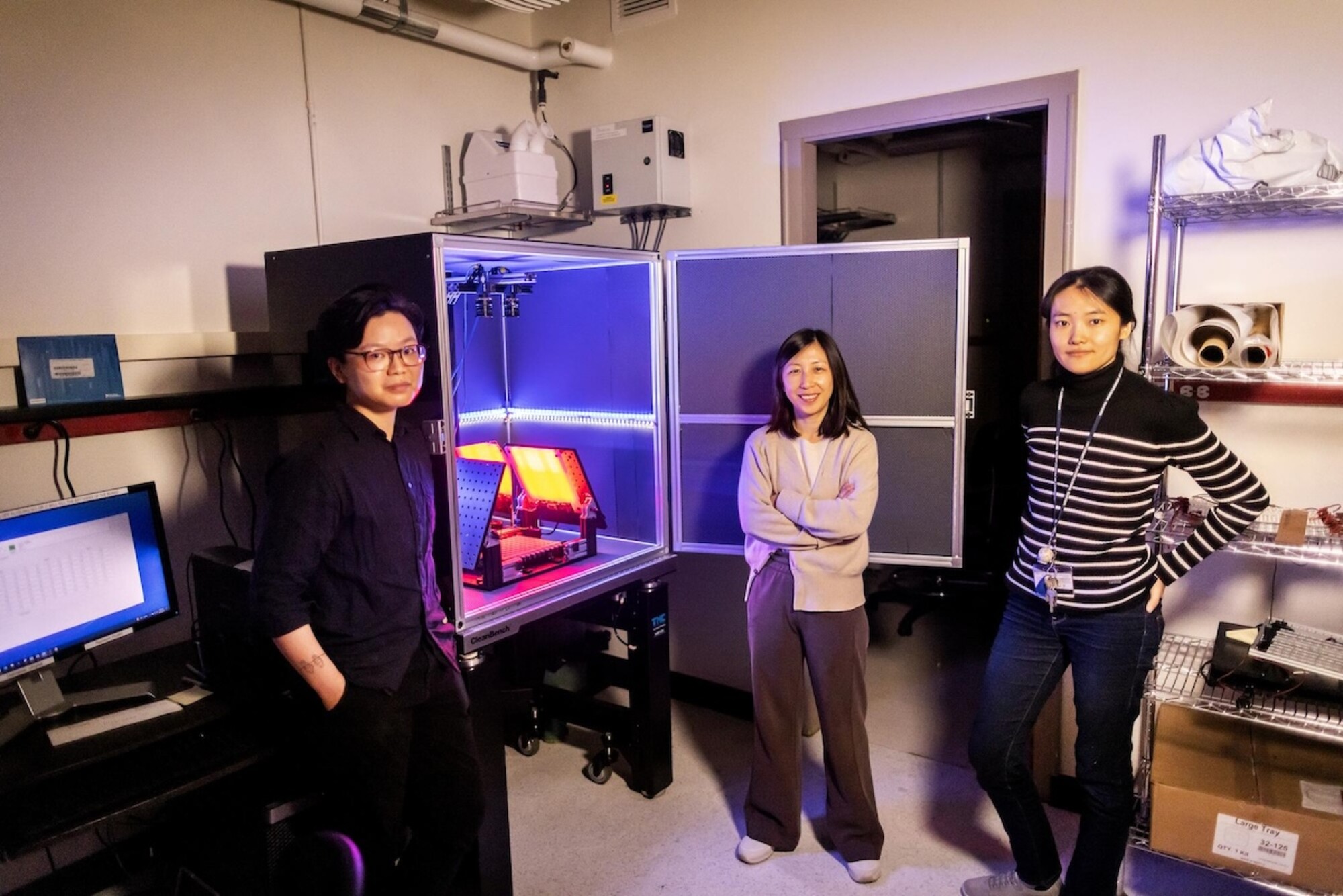 Researchers pose next to a box they fabricated for recording fly courtship.