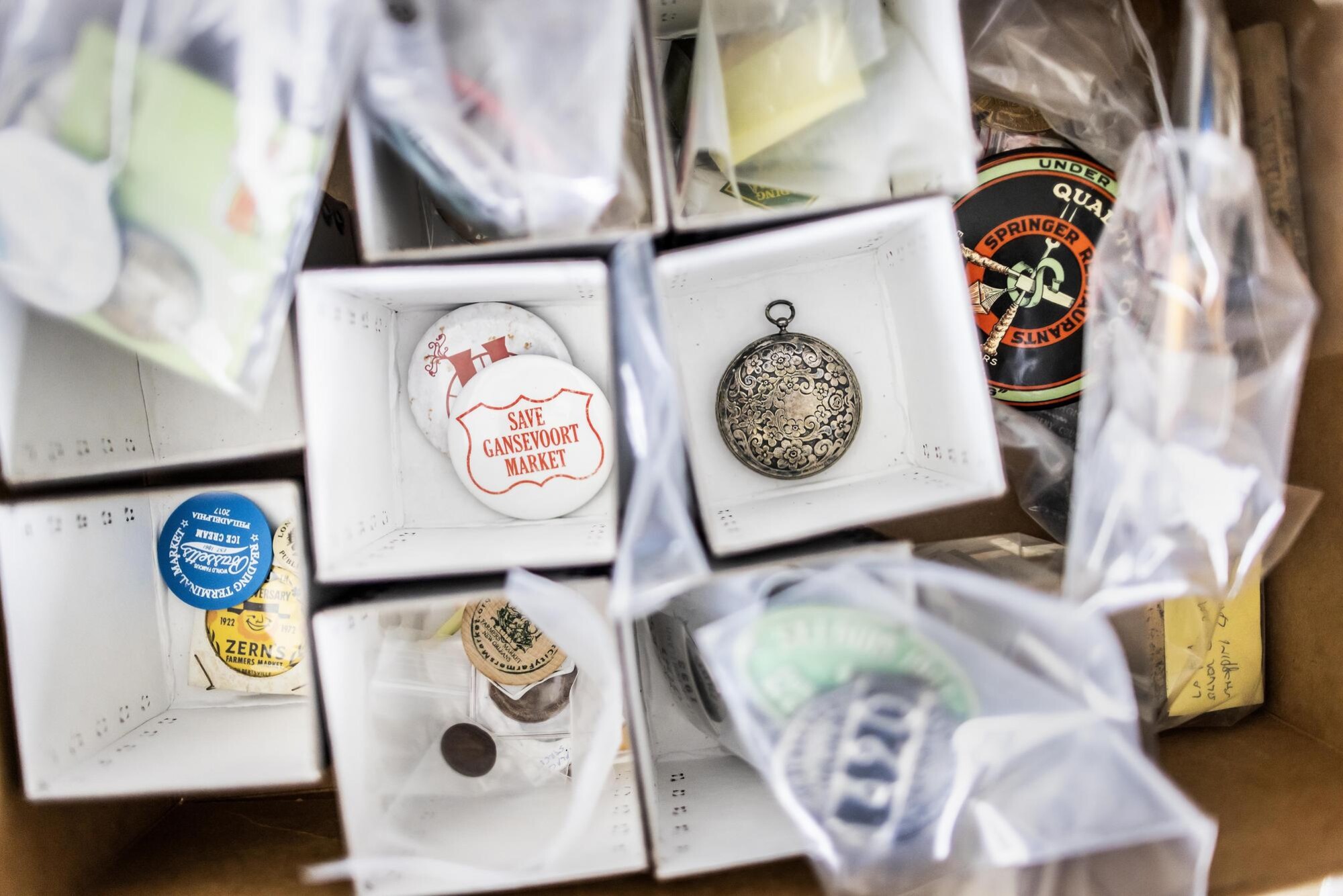 Old buttons and medals in boxes from historic public markets.