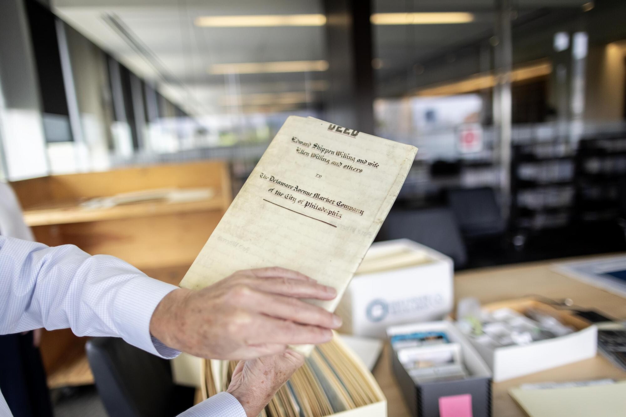 A library archivist holds a historic deed of a public market.