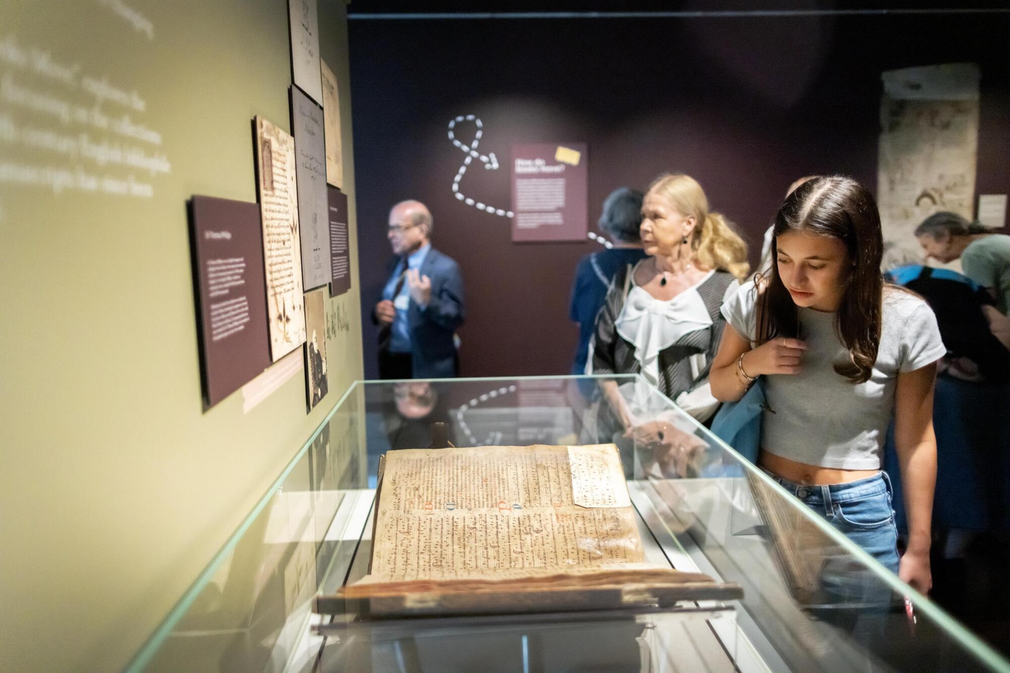 people looking at books in glass cases