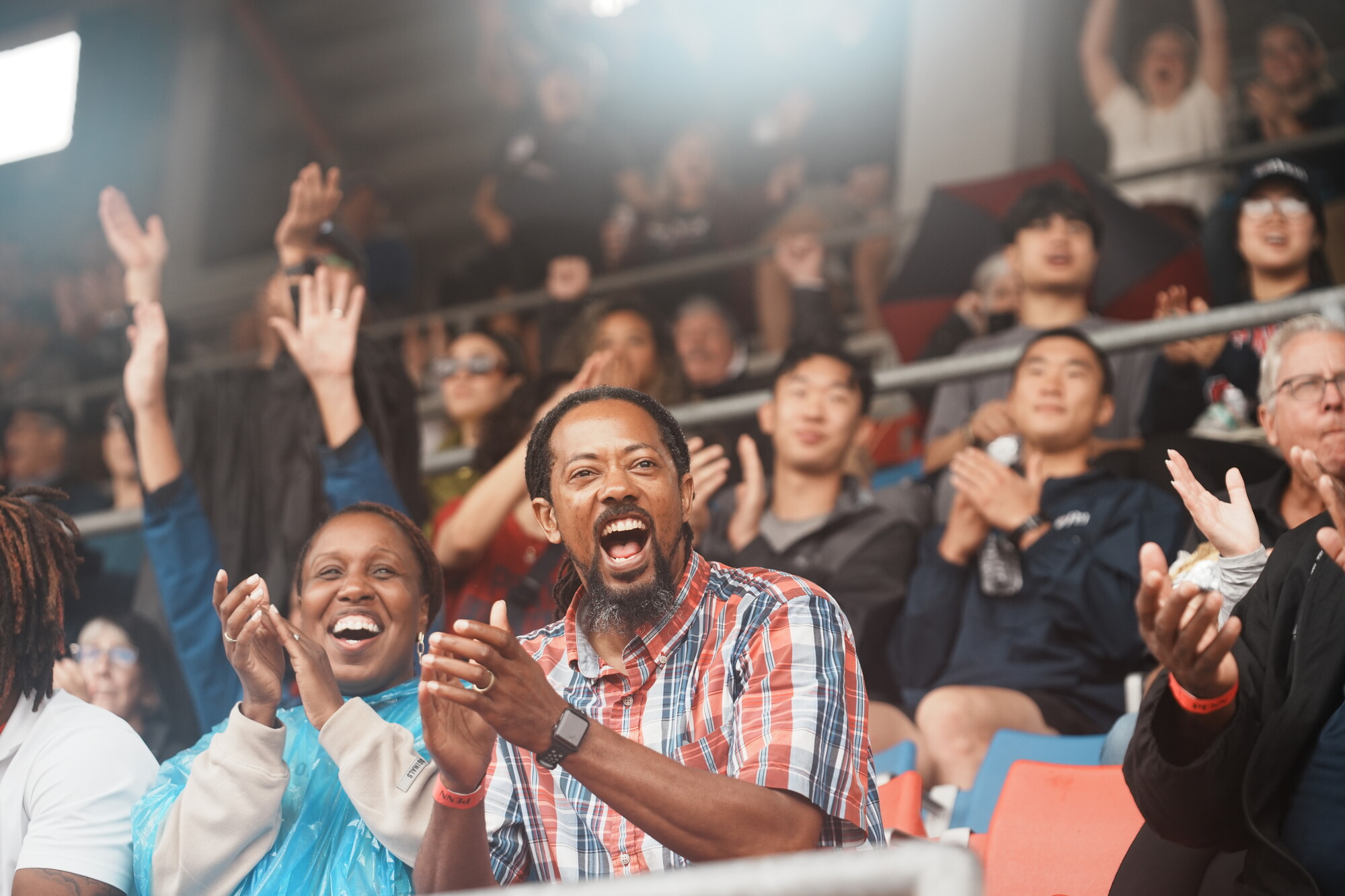 People cheering on a sporting event in the bleachers of a stadium at Penn.