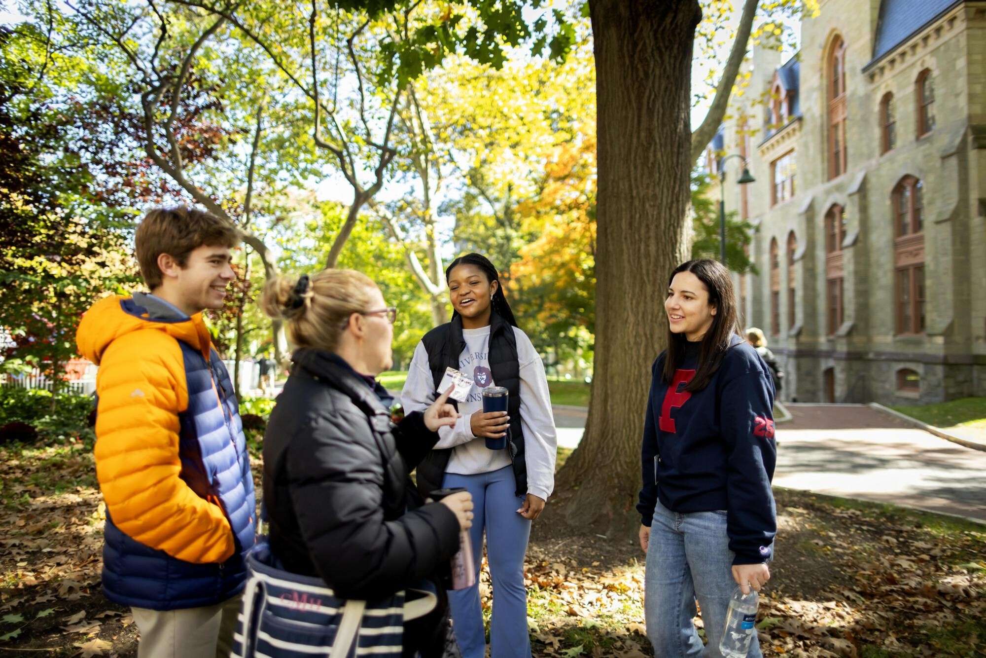 Two members of Penn’s Kite and Key talking to a prospective student and their parent on Penn’s campus.