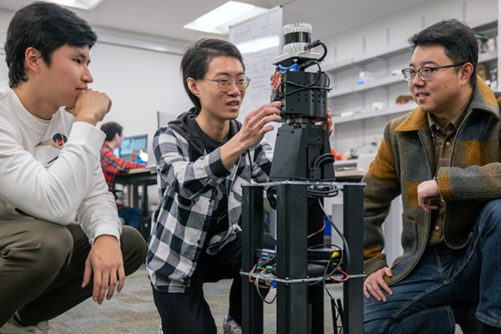 (From left) Freddy Liu, Haowen Lai, and Mingmin Zhao, assistant professor in CIS, setting up a robot equipped with PanoRadar for a test run.