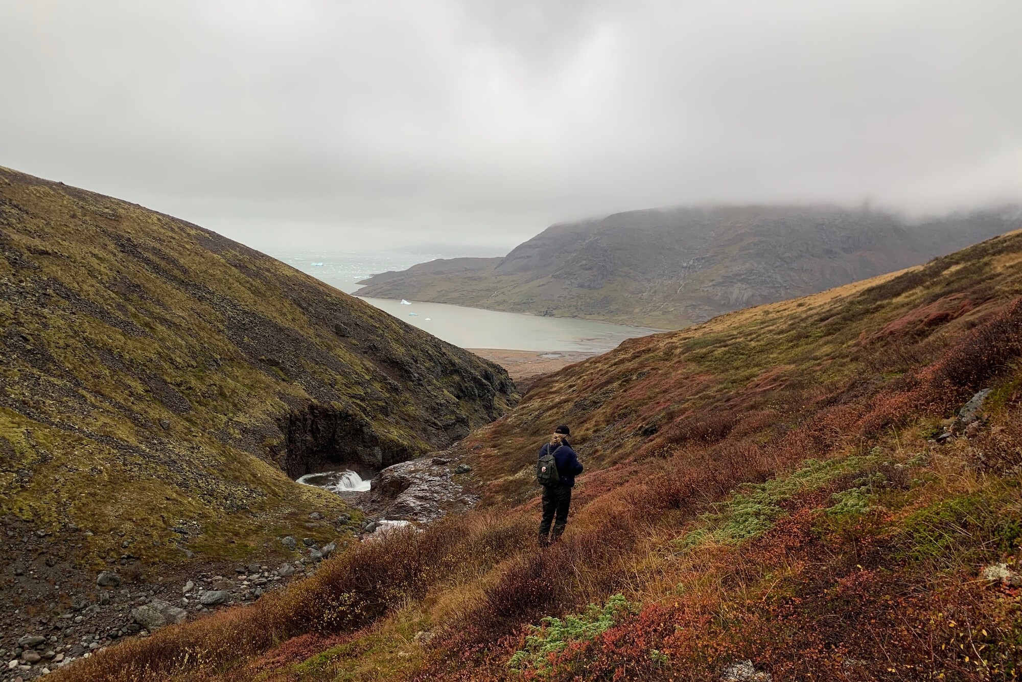 A Penn student hiking in mountains in Greenland.