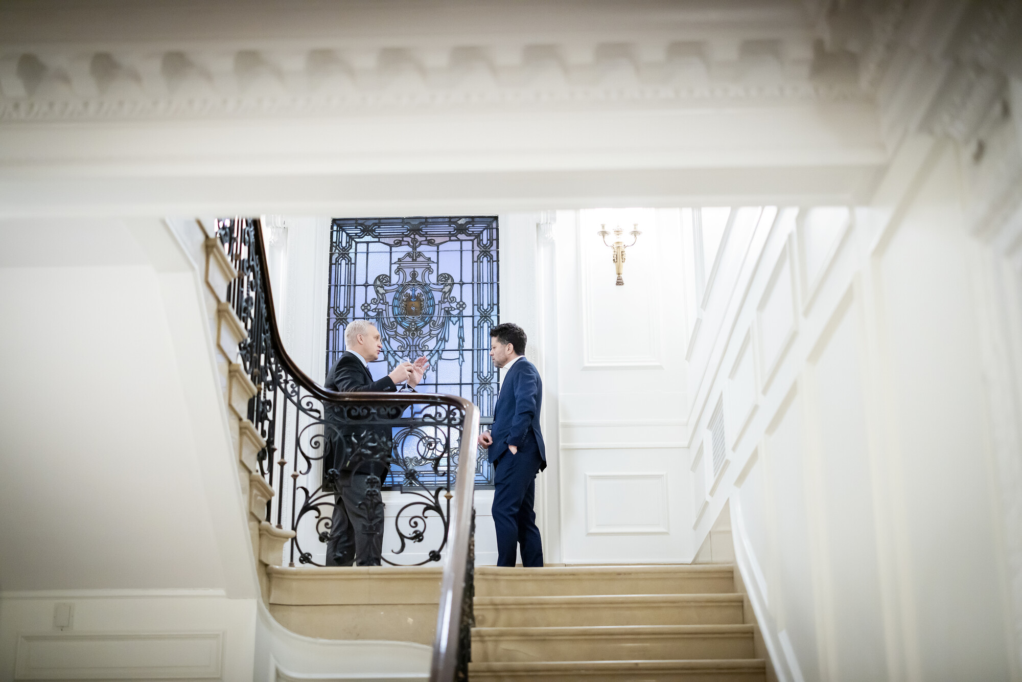 Mark Kocent and Peter cook as seen from the bottom of a staircase.