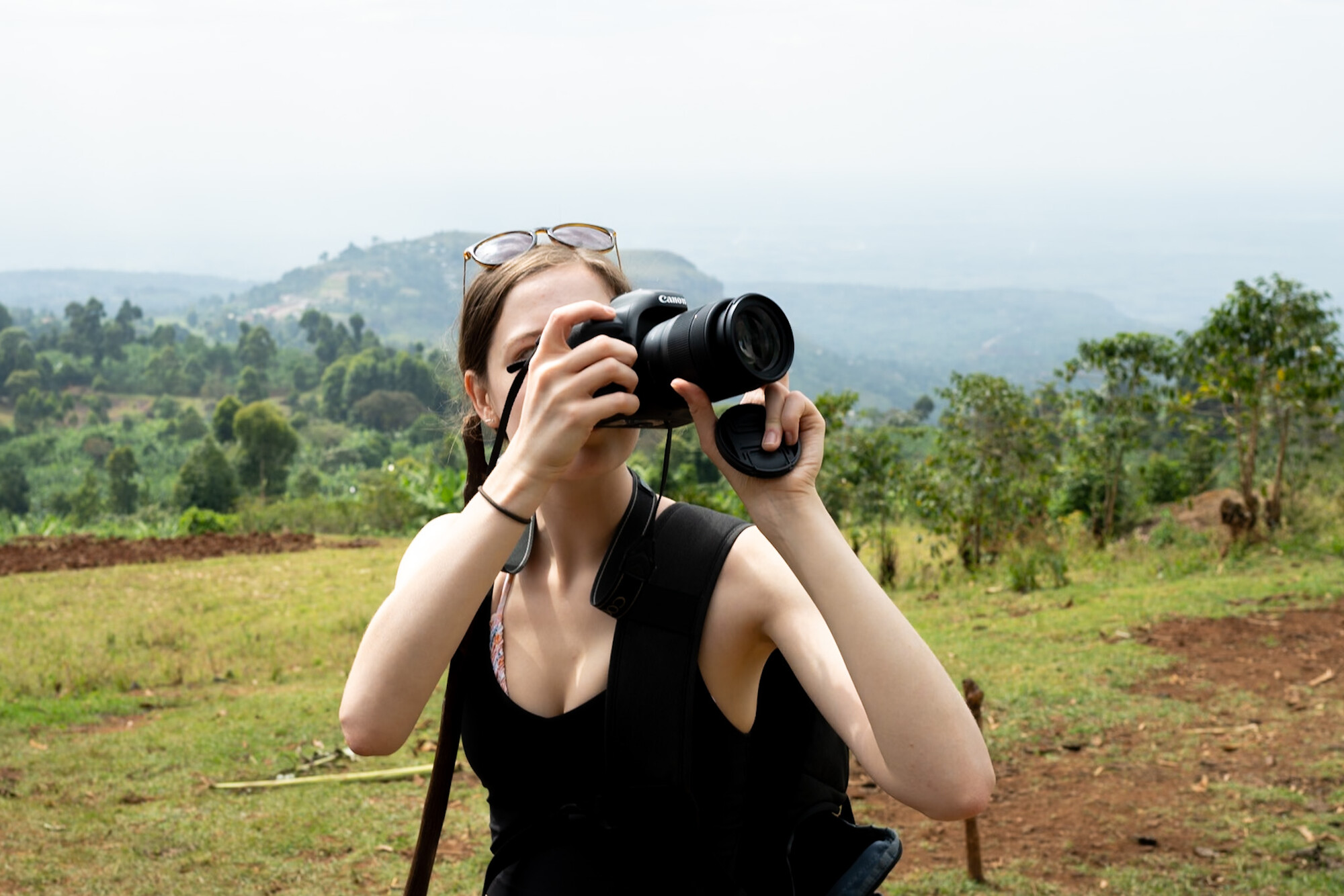 Student taking a photo with a big camera outside in the countryside. 