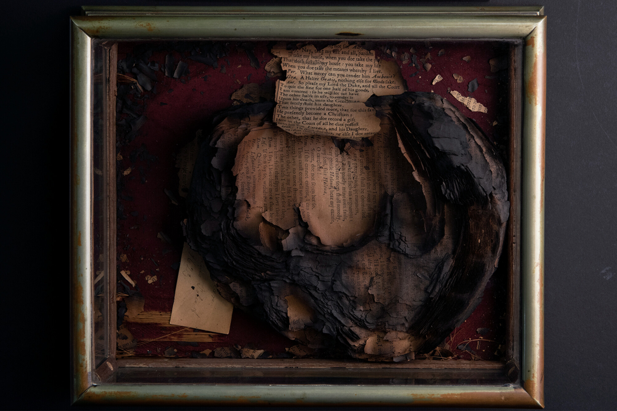 a burned Shakespeare Folio in a glass box