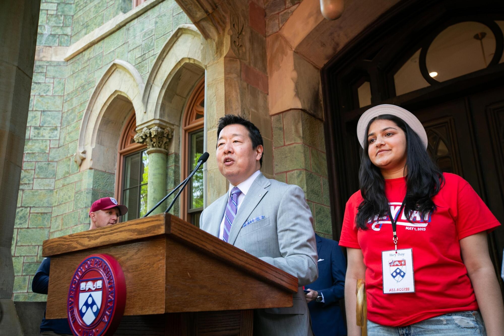 Karu Kozuma and a Penn student at the podium on the steps of College Hall during Hey Day.