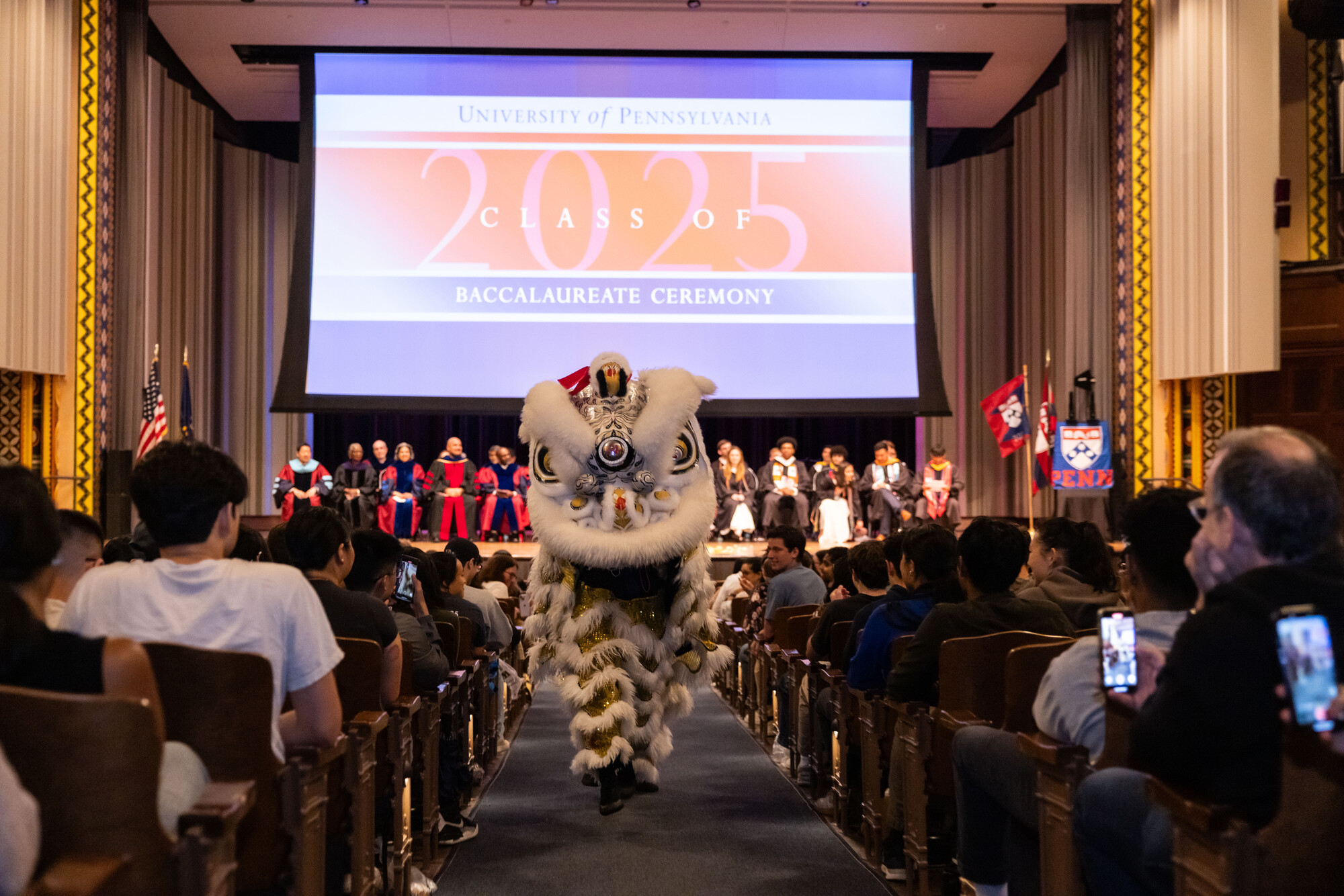 A mascot walking down the aisle at Penn’s Baccalaureate celebration.