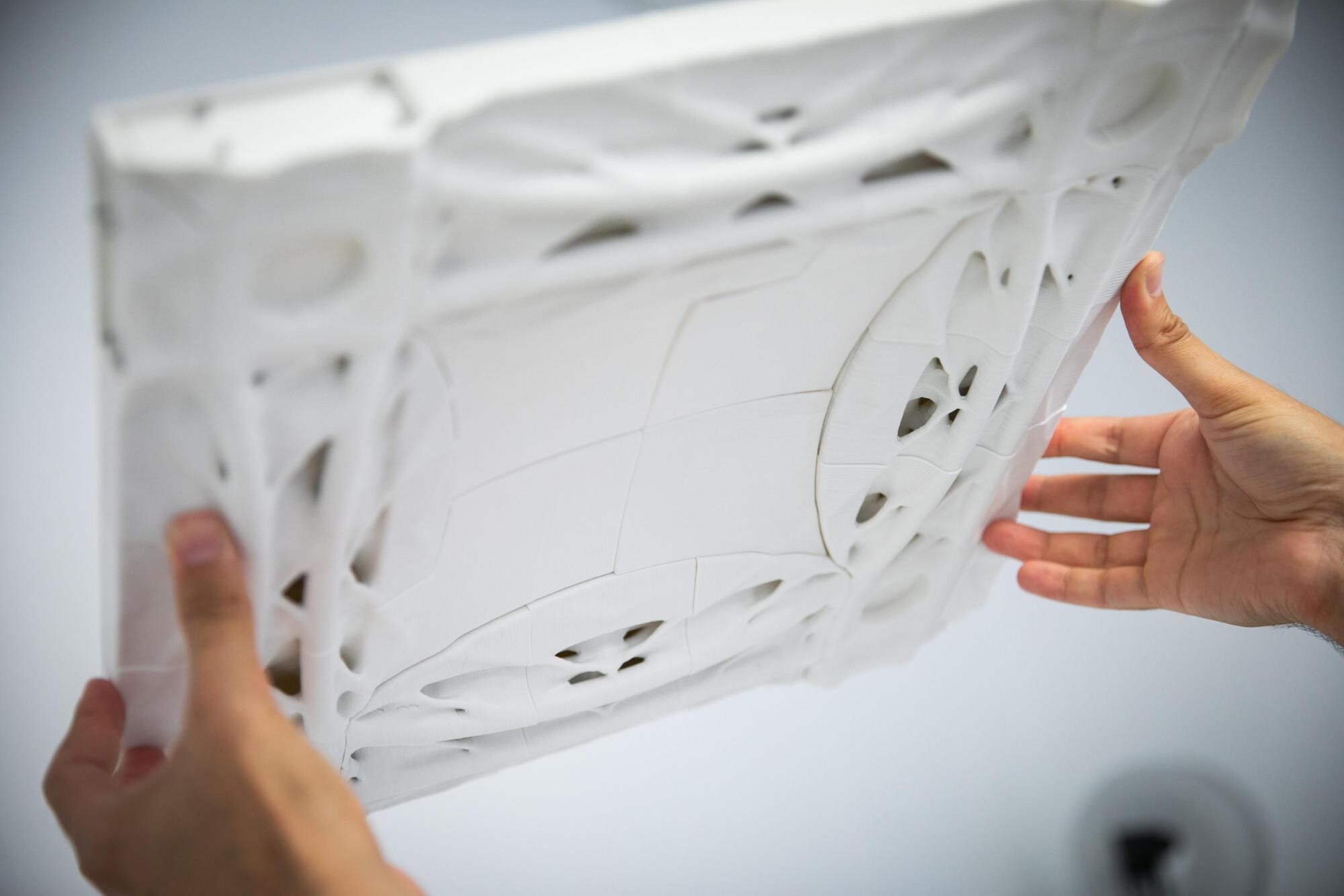Hands holding up one of the fabricated materials.
