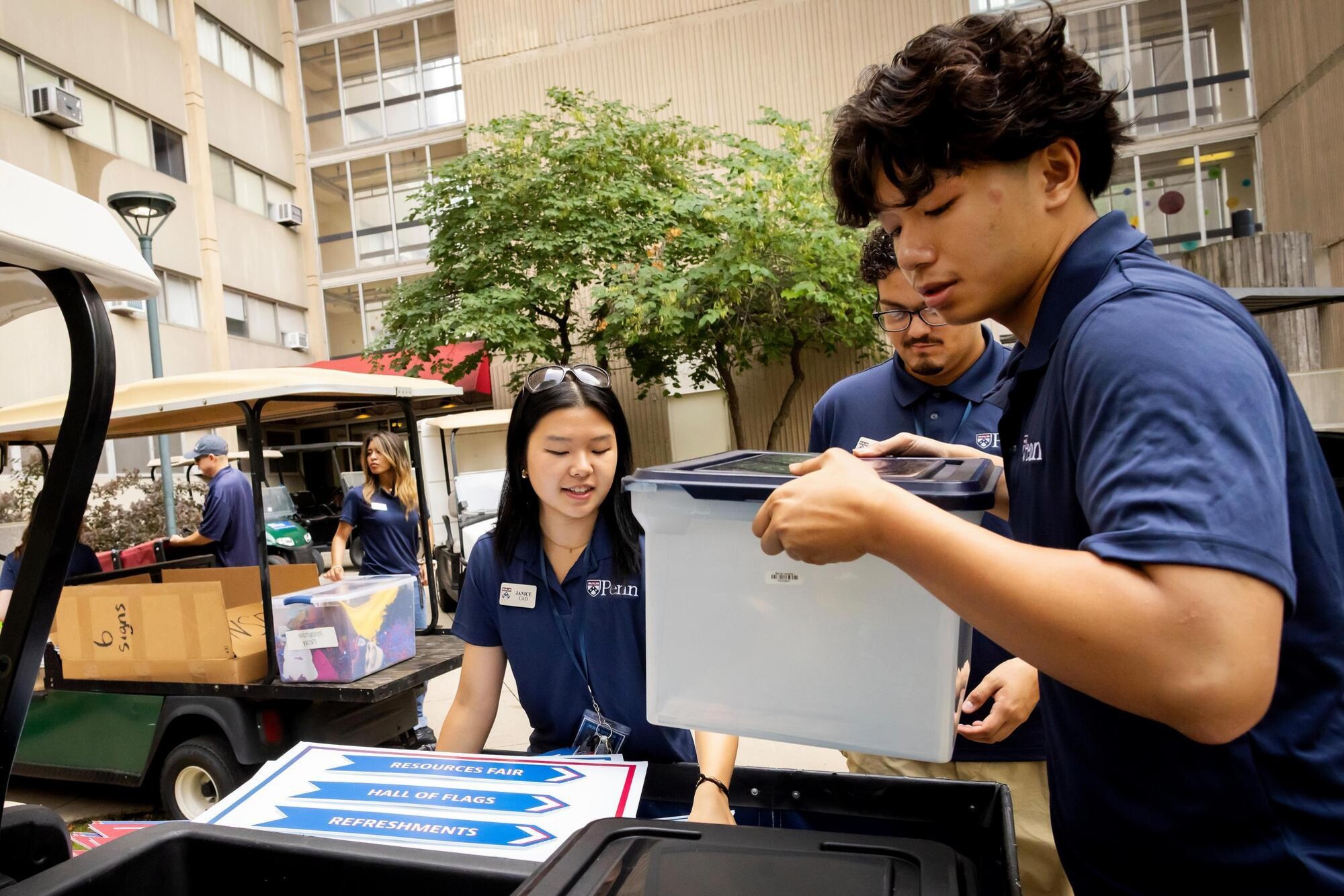 Student volunteers unloading boxes from a cart before Move-In