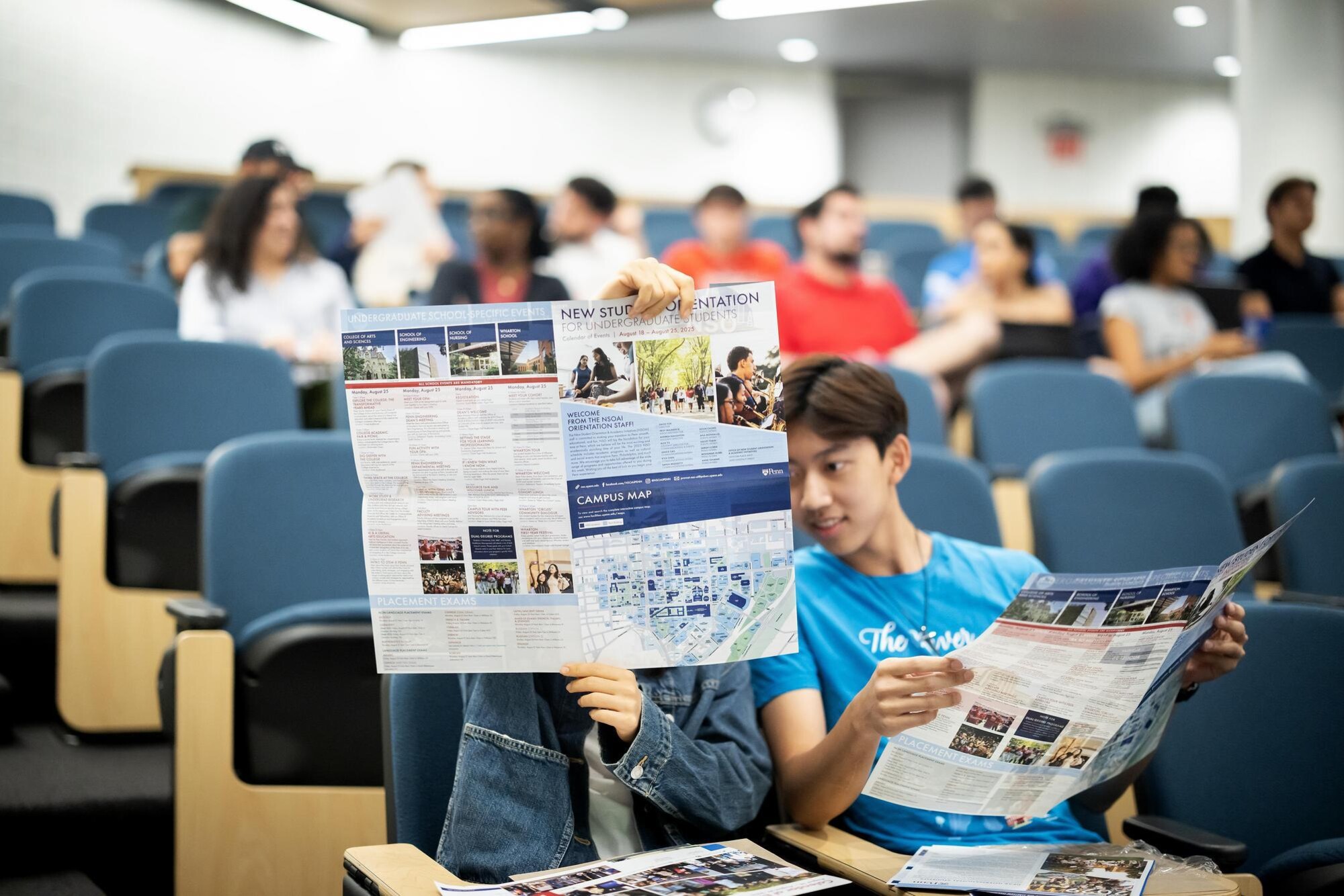 Two students looking at a new student orientation brochure.