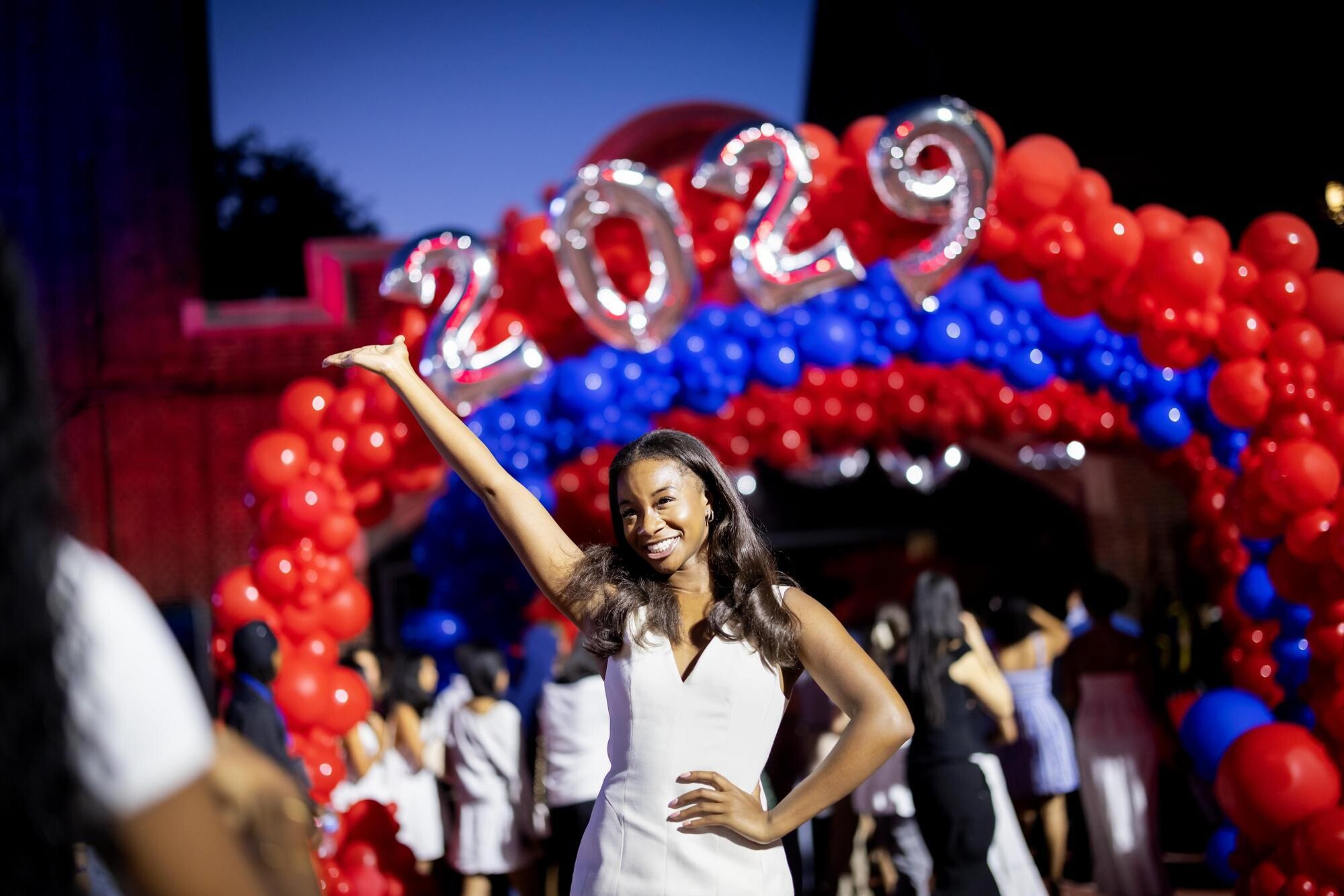 A student poses for a photo in front of a 2029 balloon banner during Penn’s convocation.